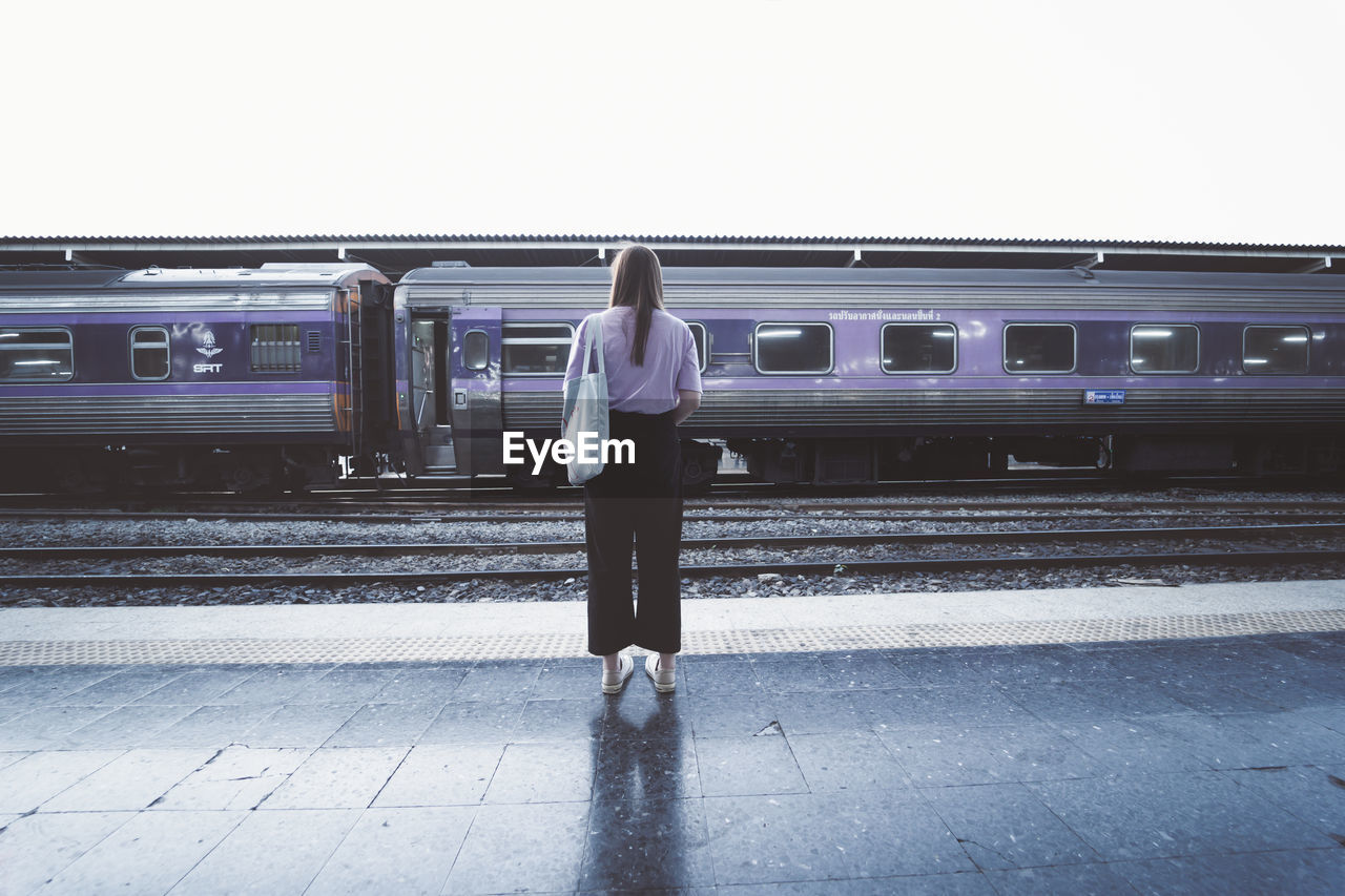 FULL LENGTH REAR VIEW OF WOMAN ON TRAIN AT RAILROAD STATION