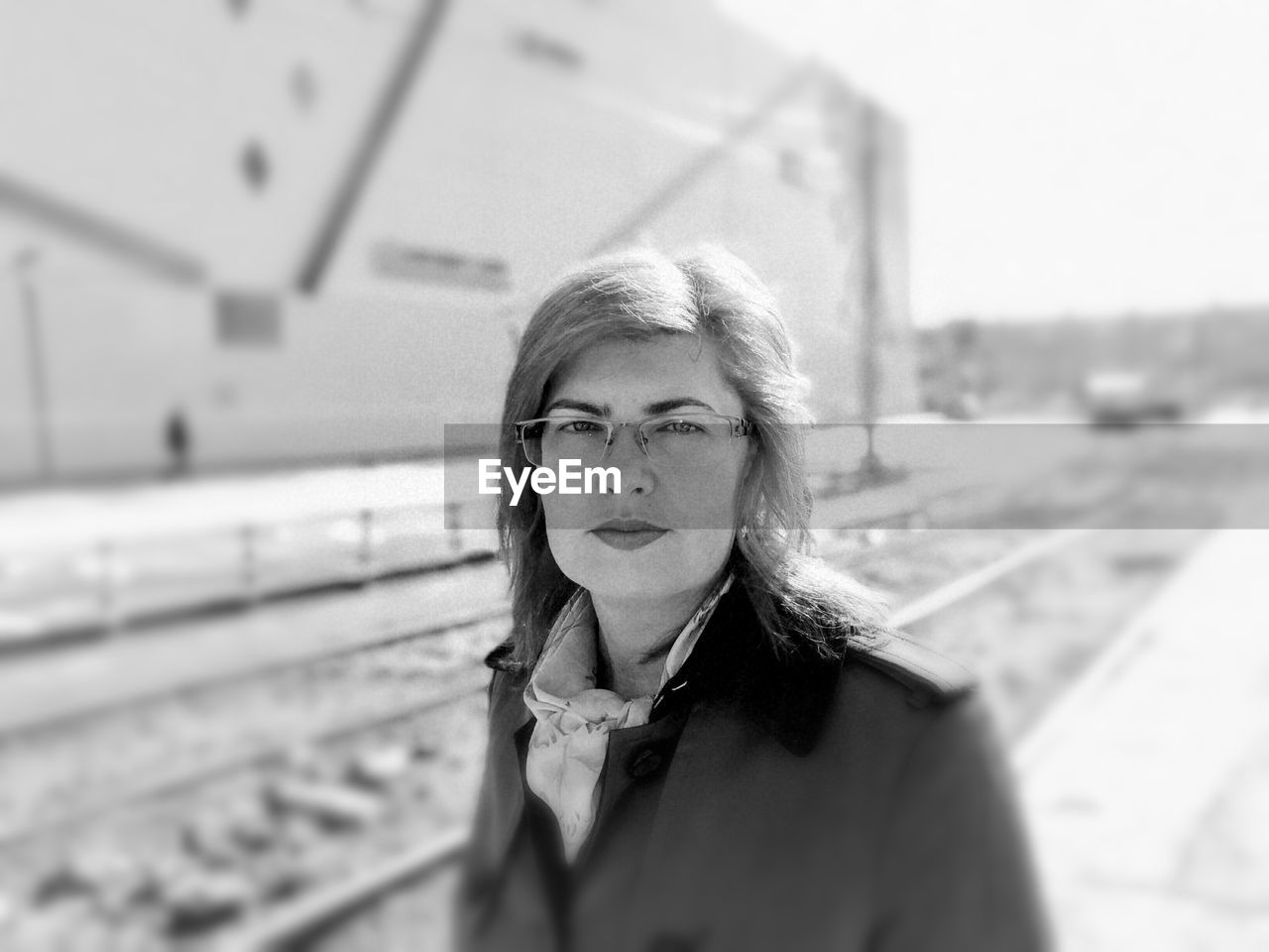 Portrait of woman standing by railroad track