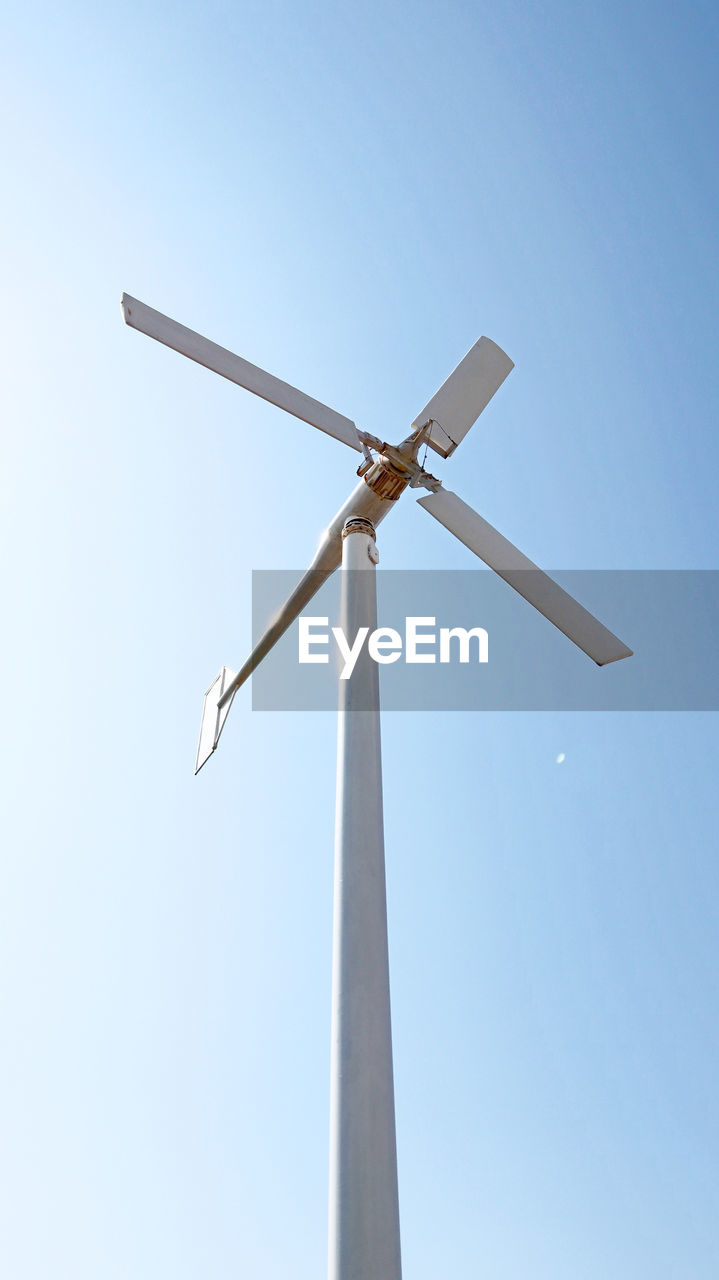 Low angle view of wind turbine against clear sky during sunny day