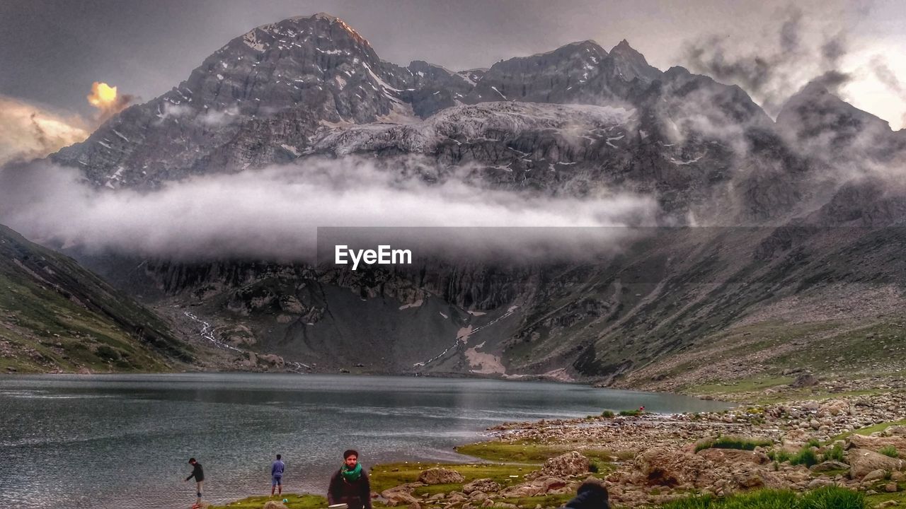 PEOPLE IN WATER AGAINST MOUNTAINS