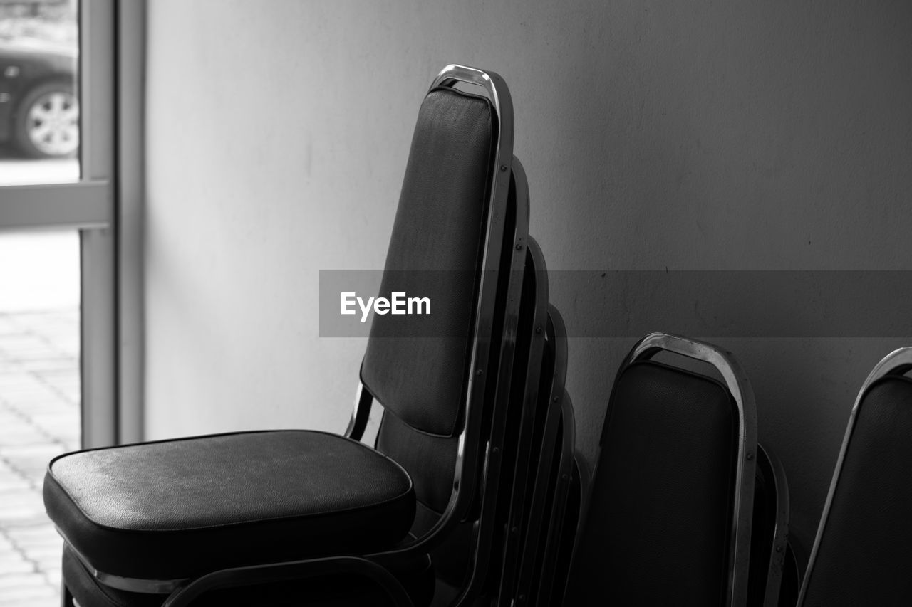 CLOSE-UP OF EMPTY SEATS ON TABLE AGAINST WALL