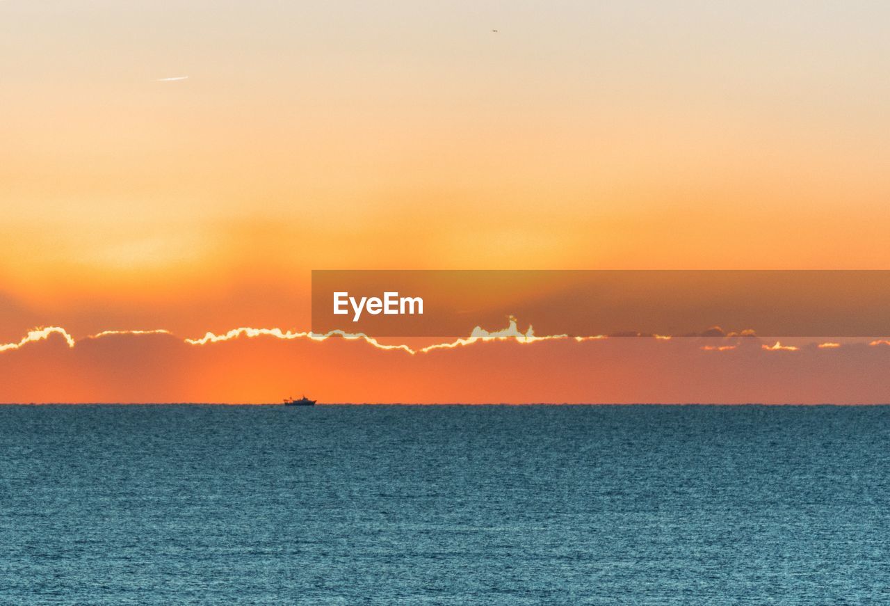 Scenic view of sea against romantic sky at sunset