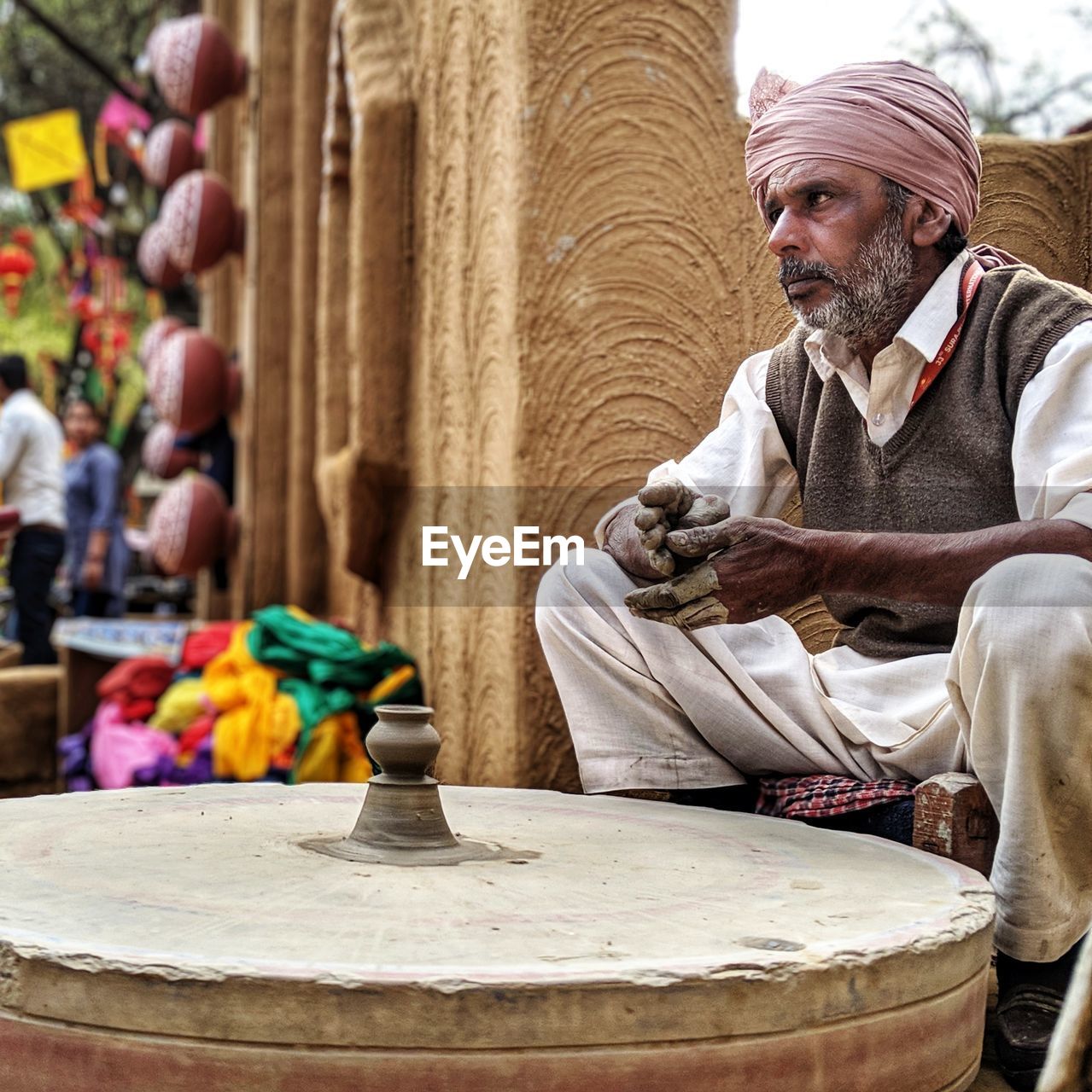 Man working on pottery wheel at market
