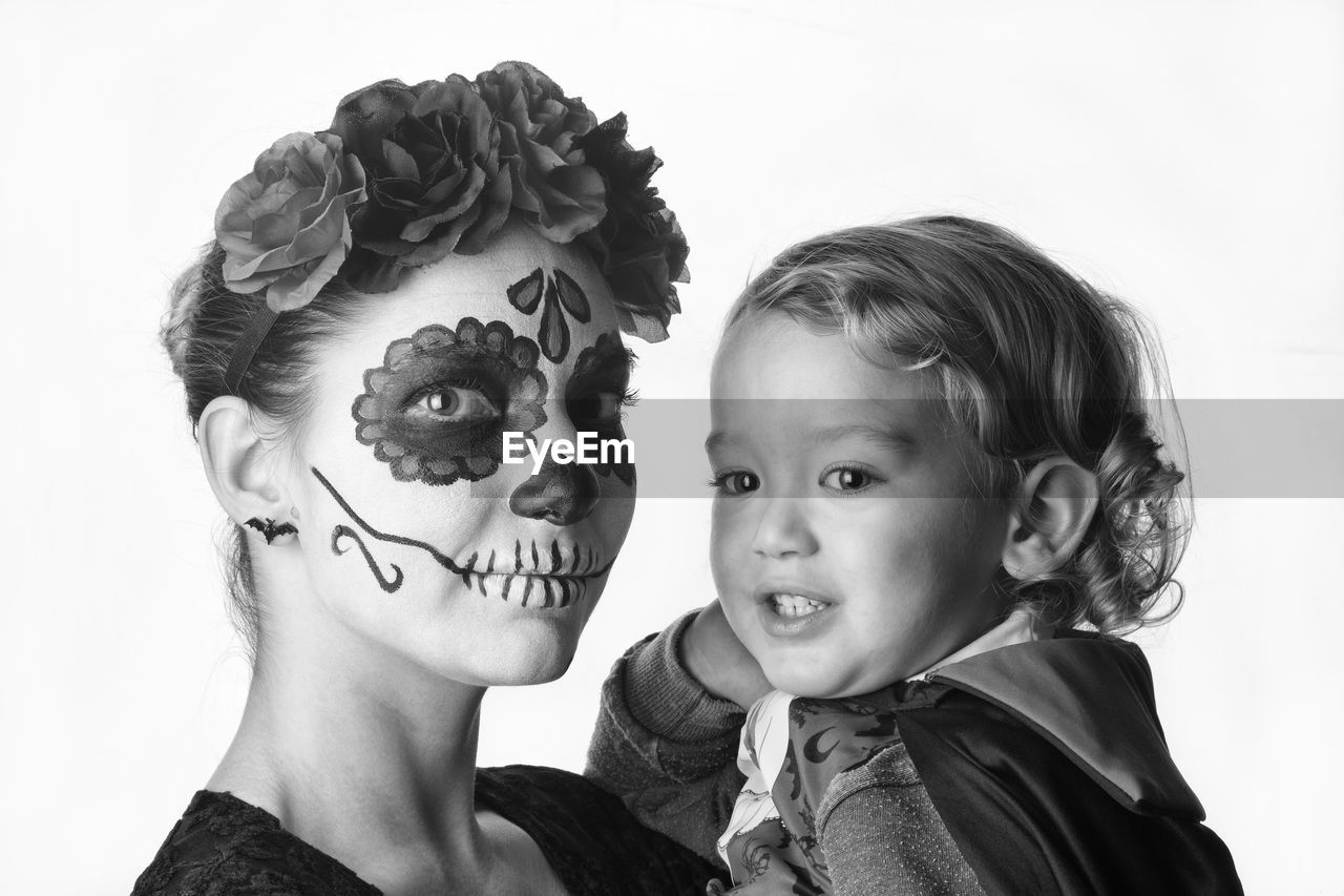 CLOSE-UP PORTRAIT OF MOTHER AND GIRL AGAINST WHITE BACKGROUND