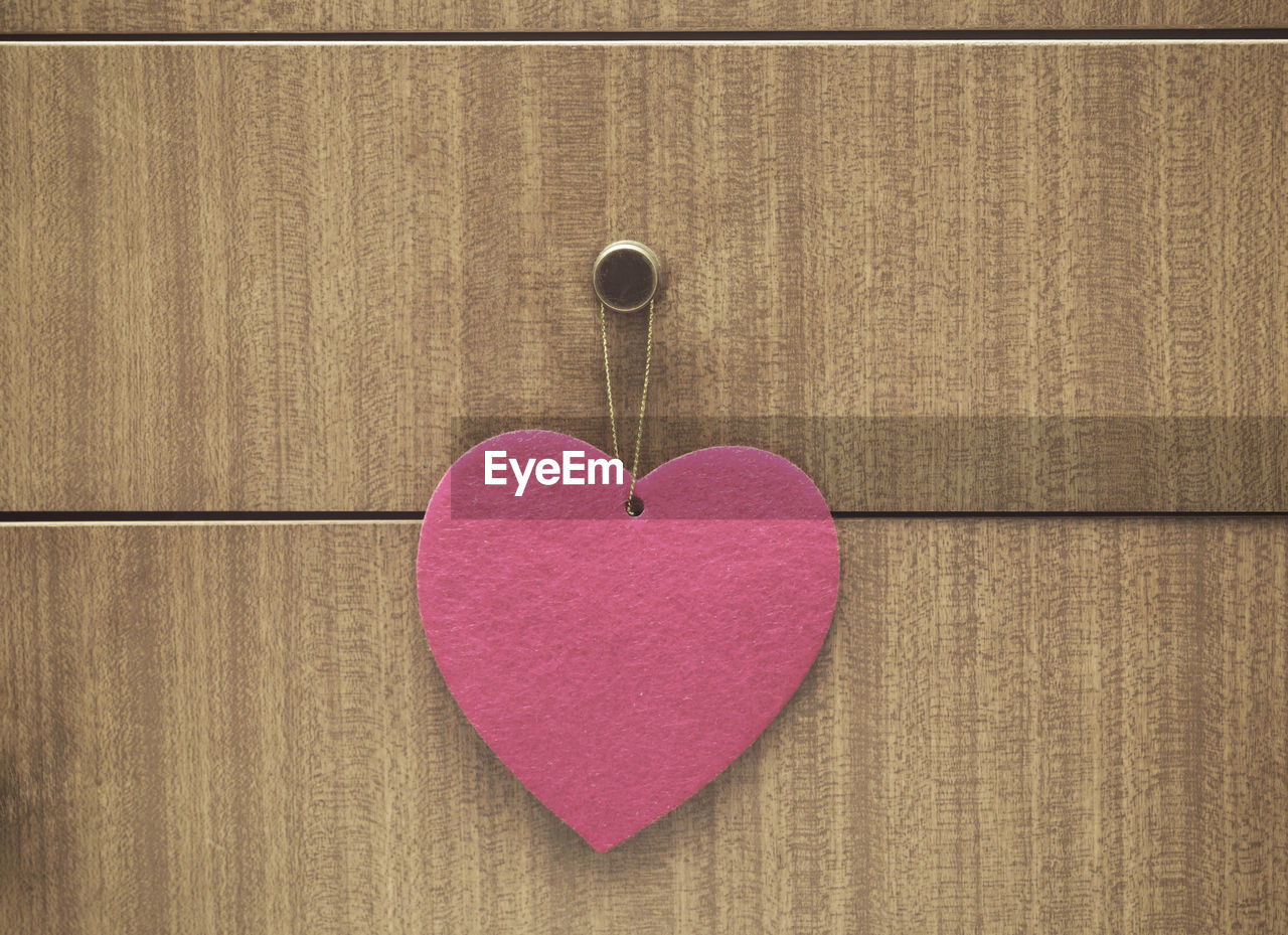 CLOSE-UP OF HEART SHAPE MADE ON PINK PAPER