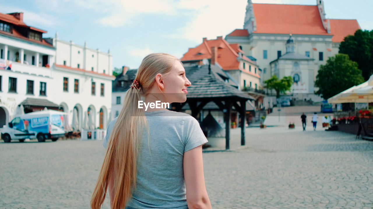 side view of young woman standing on street