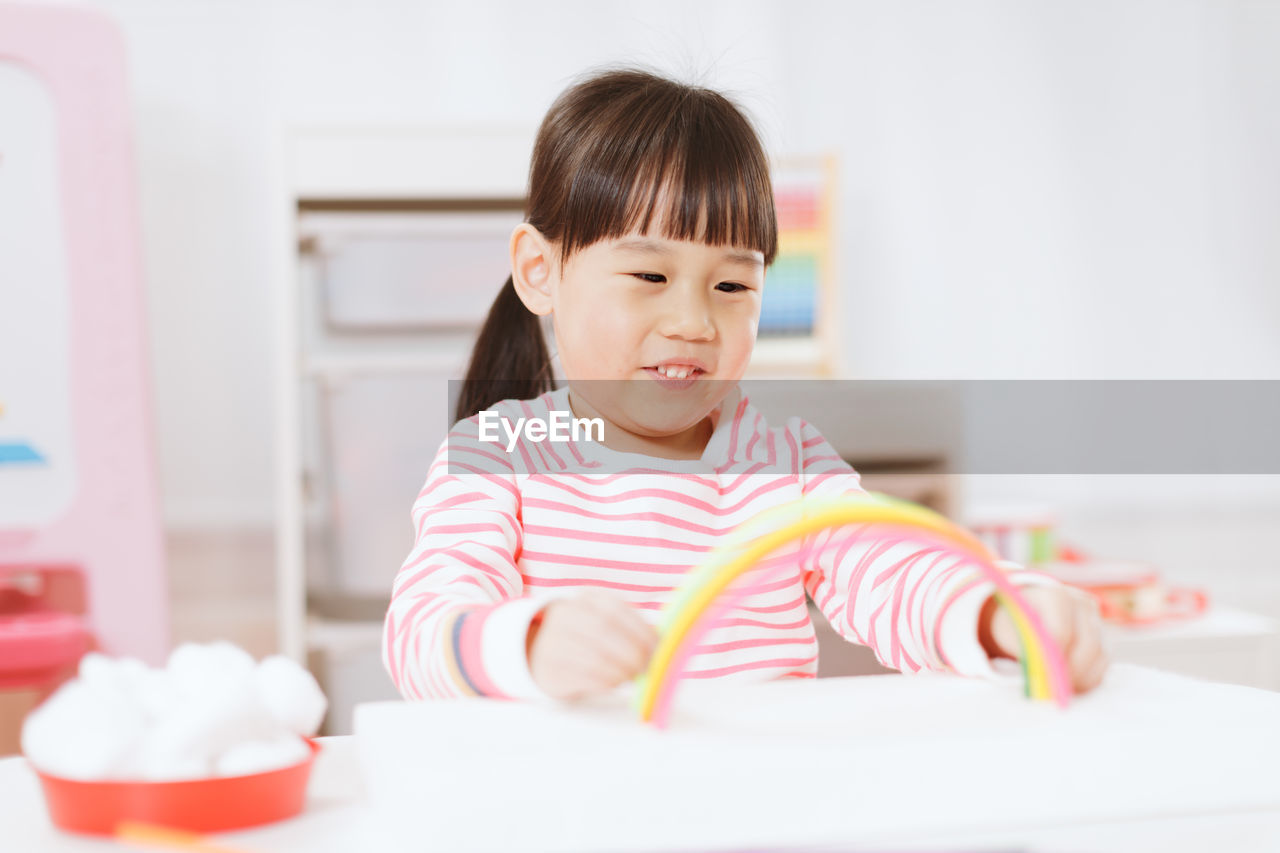 Cute smiling girl playing with toy