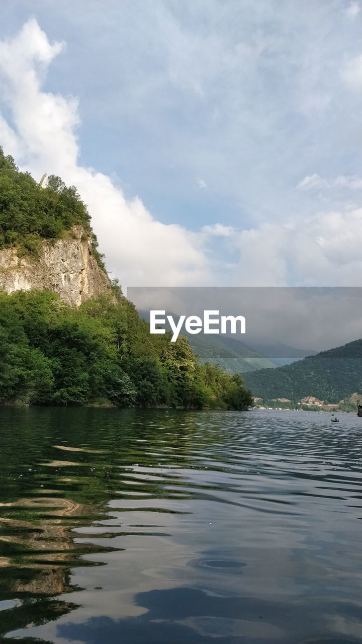 Scenic view of lake by mountain against sky