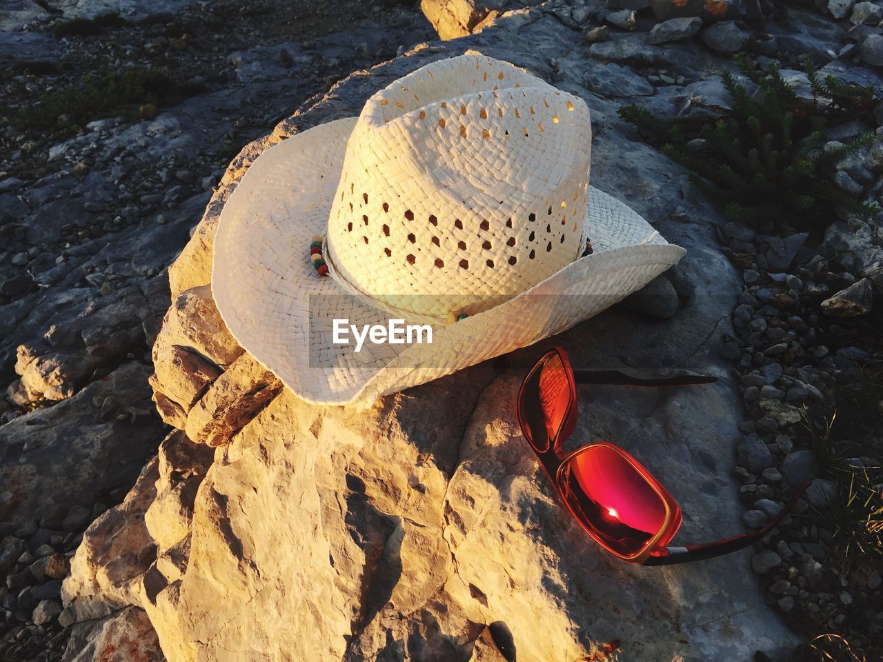 High angle view of sunhat and sunglasses on rock