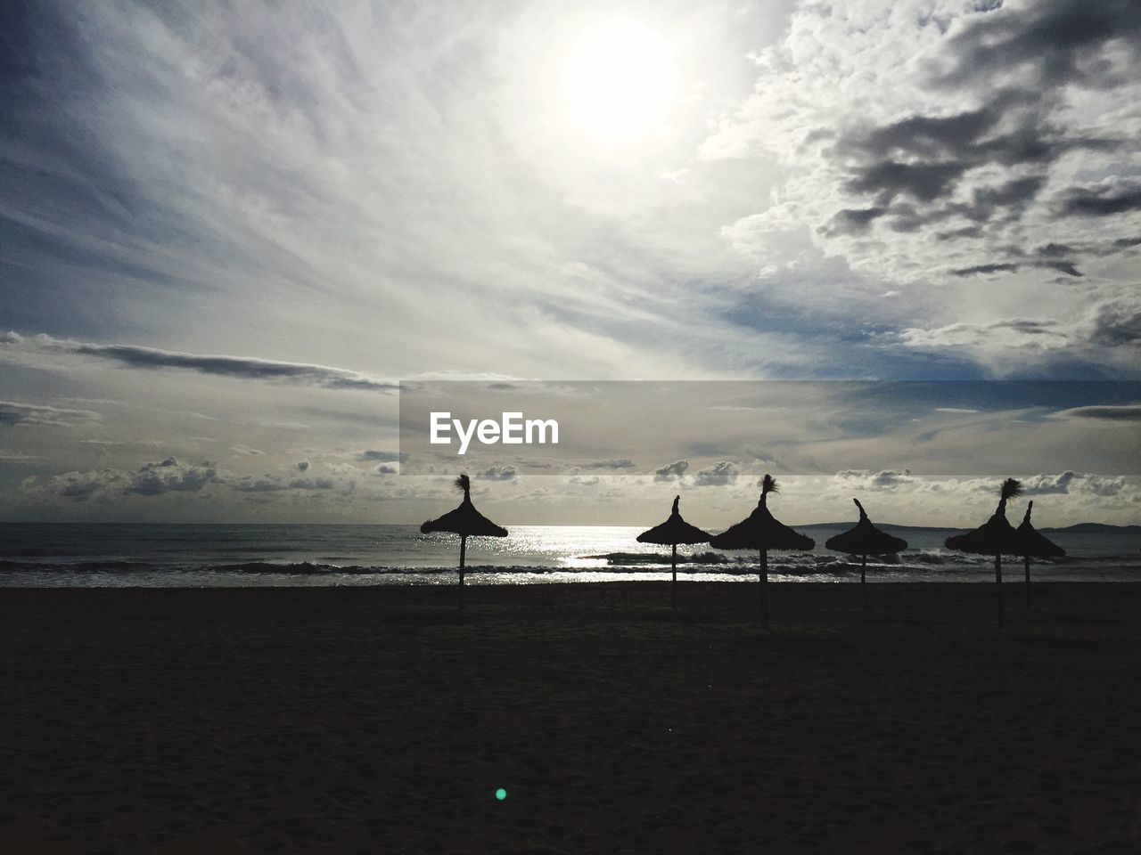 Scenic view of beach against cloudy sky