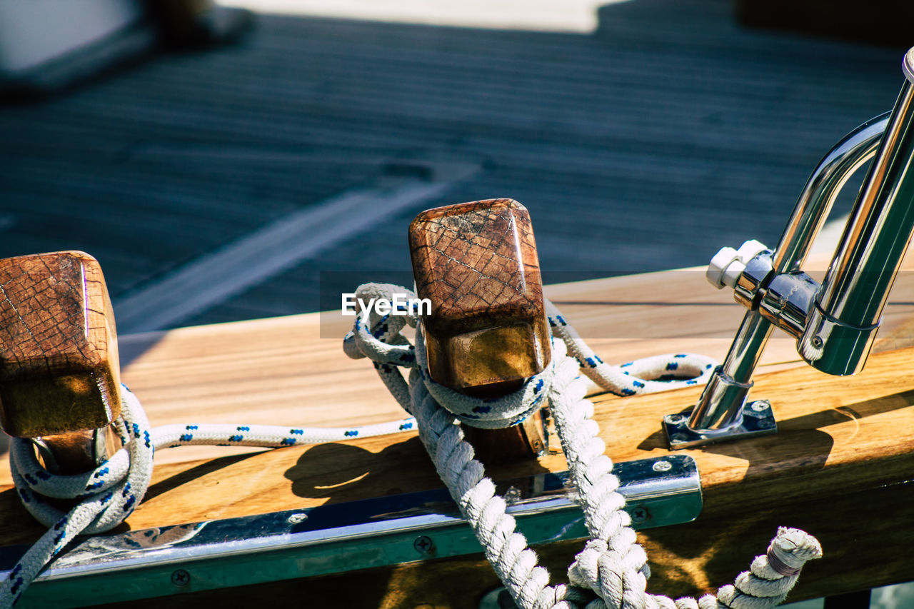 CLOSE-UP OF ROPE TIED ON WOODEN POST