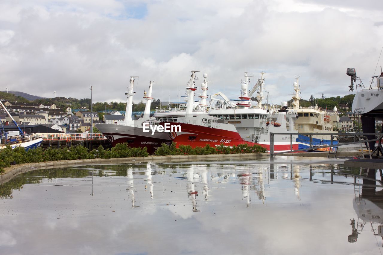 BOATS MOORED AT HARBOR