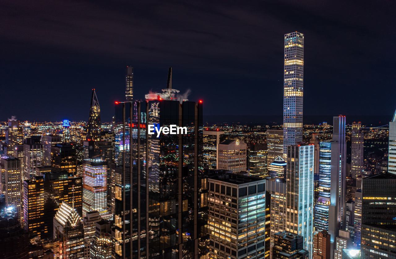 high angle view of illuminated buildings in city at night