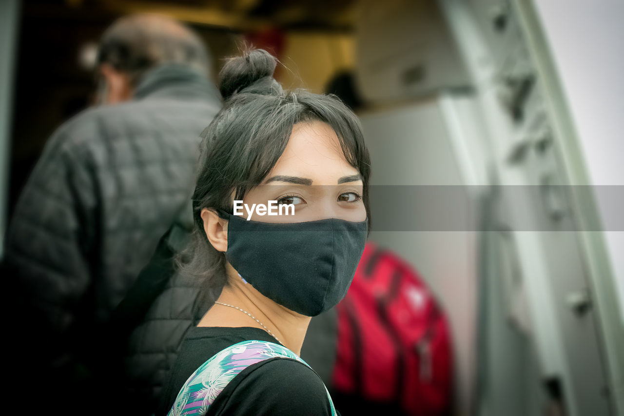 Close-up of young woman traveling wearing mask. 