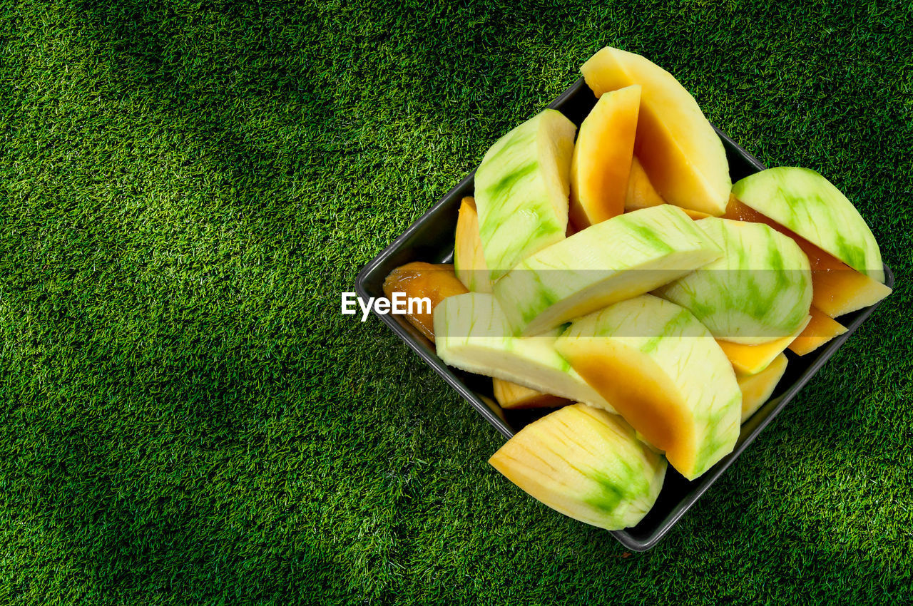 Mango,ripe mangoes ready to eat on black dish on grass background