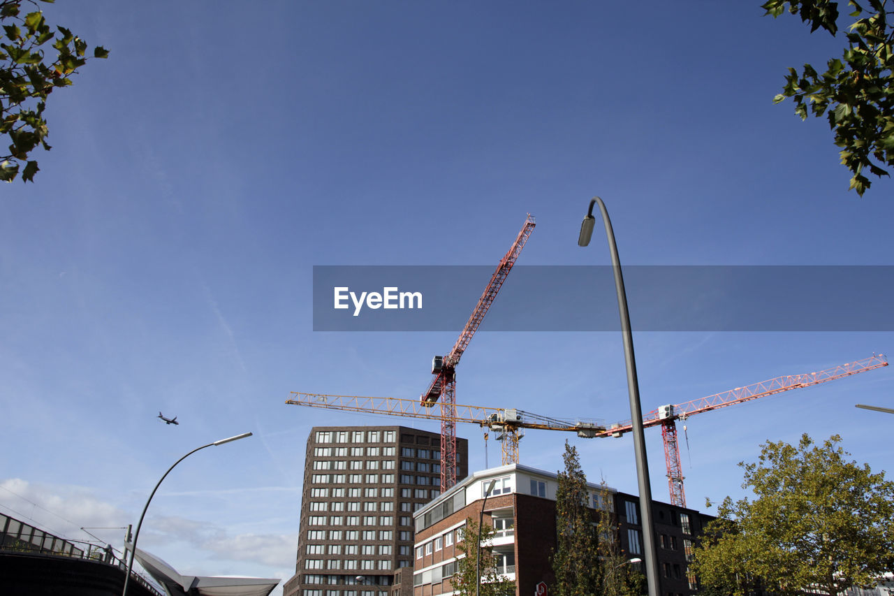 LOW ANGLE VIEW OF CRANE AGAINST BUILDING