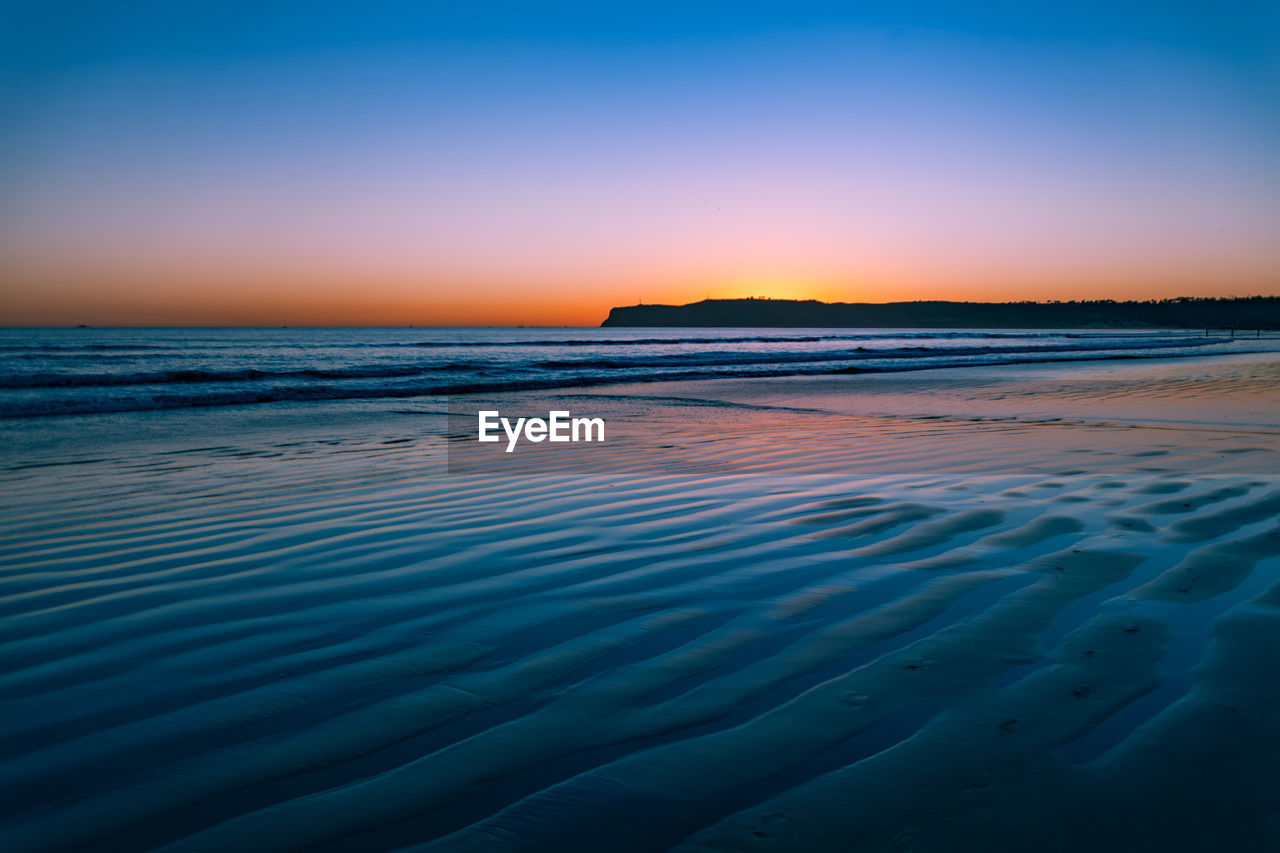 Scenic view of sea against clear sky during sunset