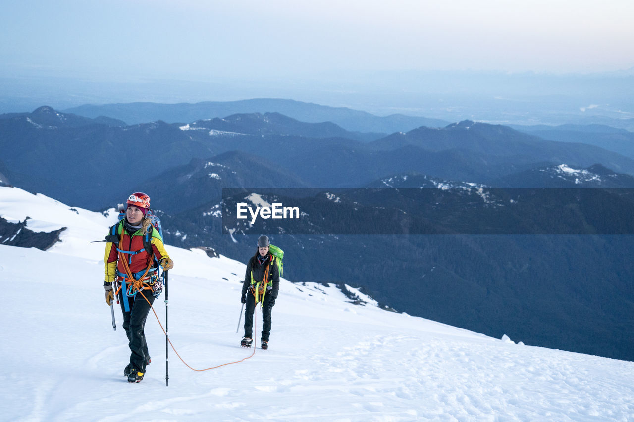 A female mountaineer looks up determinedly at the summit of mt. baker