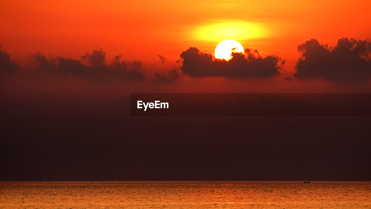 Scenic view of sea against dramatic sunset