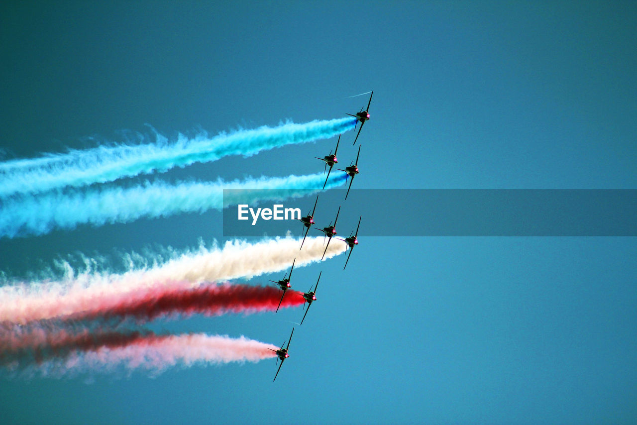 Low angle view of airshow against sky