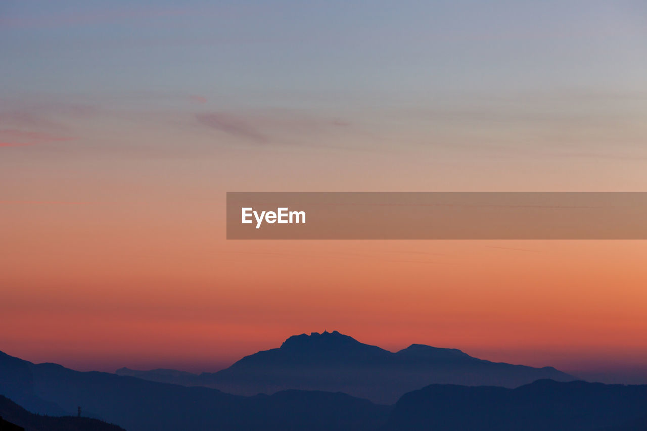 Scenic view of silhouette mountains against sky at sunset