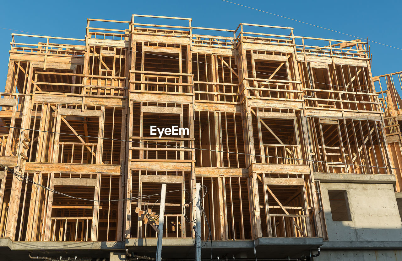 LOW ANGLE VIEW OF BUILDING AT CONSTRUCTION SITE AGAINST SKY