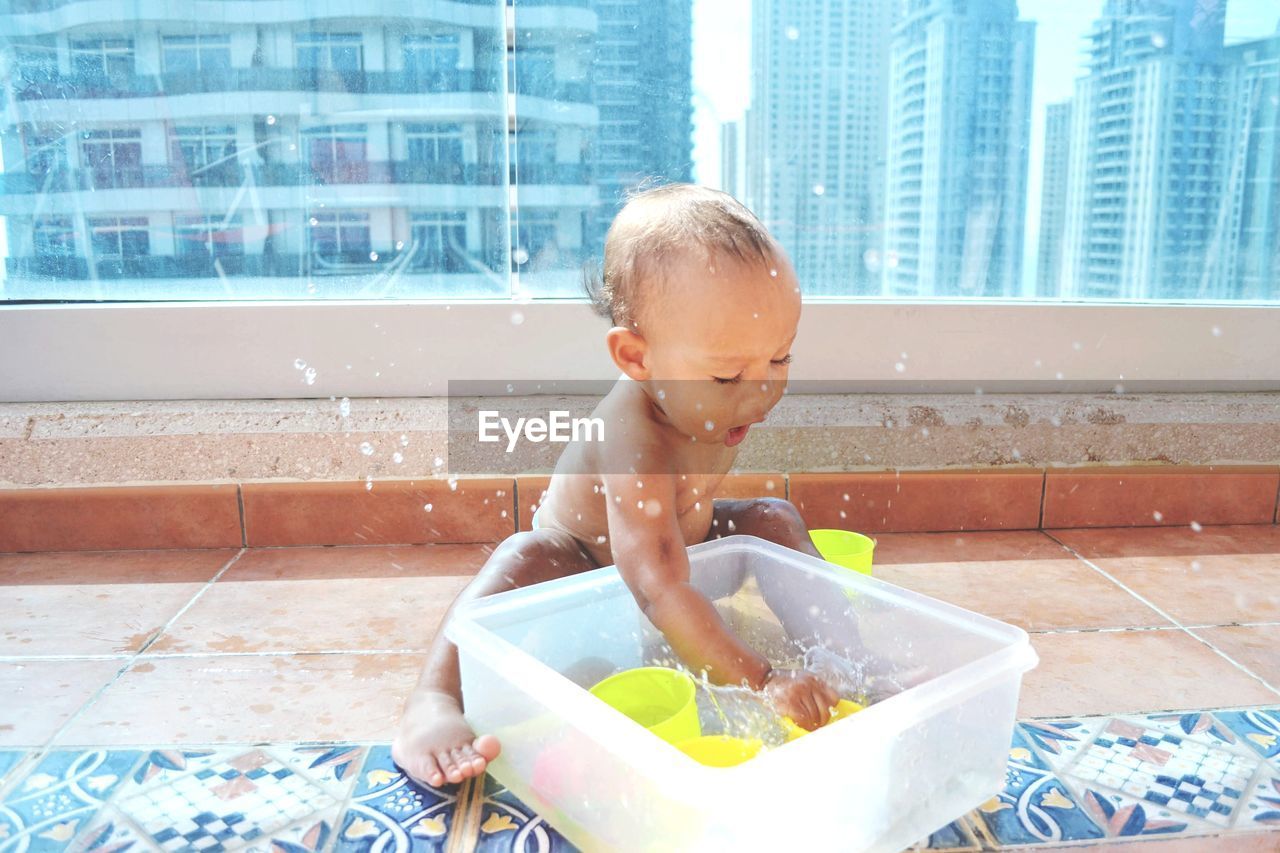 Girl splashing water in container