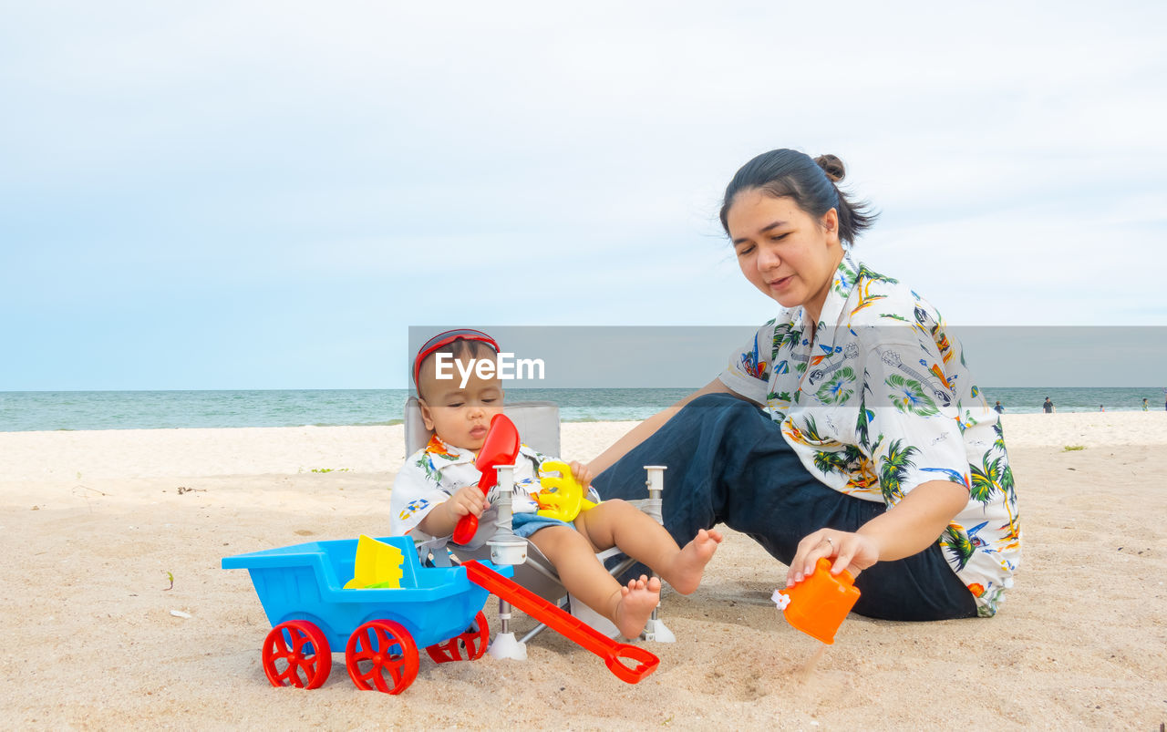 HAPPY BOY WITH TOY ON BEACH