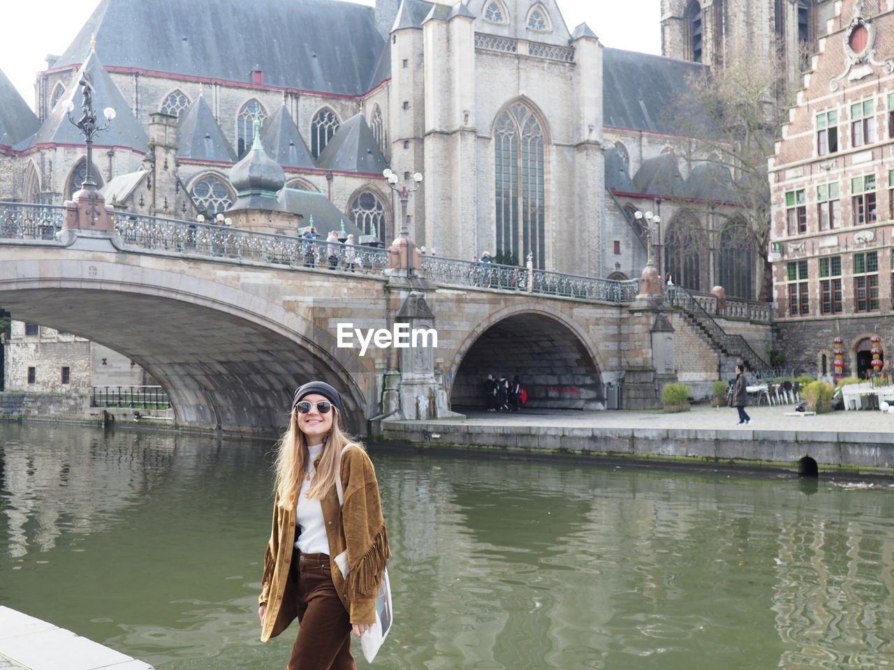Woman on bridge over river in city