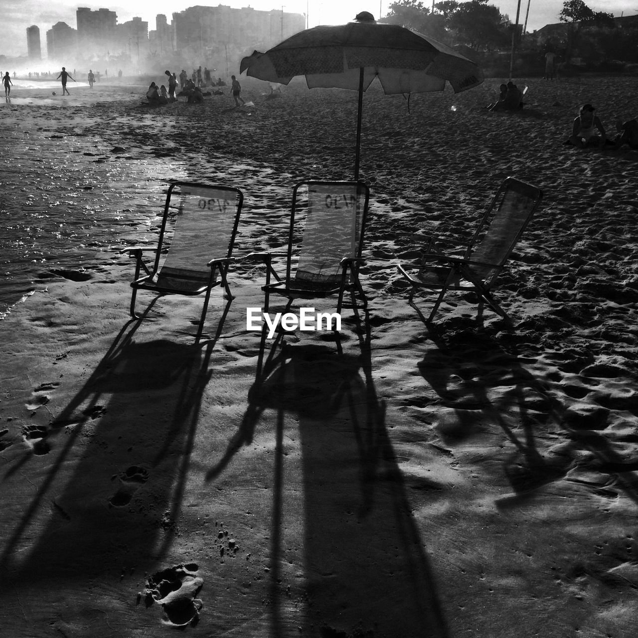 Chairs and sunshade on beach with people in background