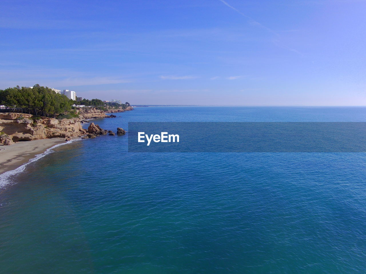 SCENIC VIEW OF BEACH AGAINST BLUE SKY