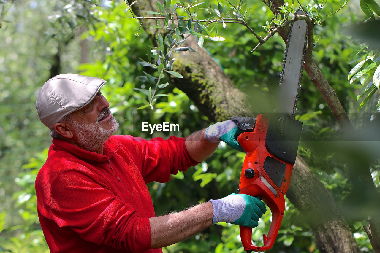 SIDE VIEW OF MAN HOLDING PLANTS