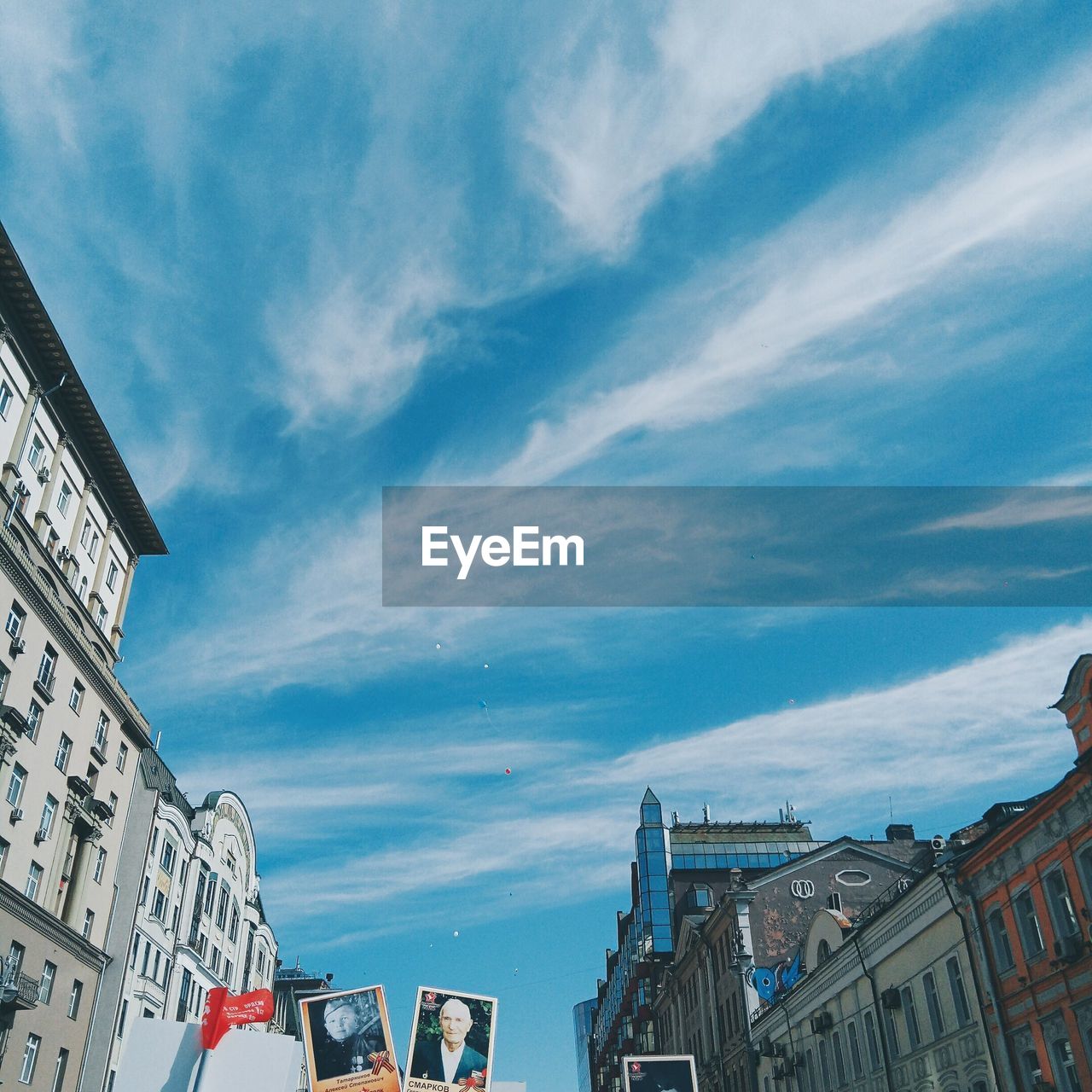 LOW ANGLE VIEW OF BUILDINGS IN CITY AGAINST CLOUDY SKY