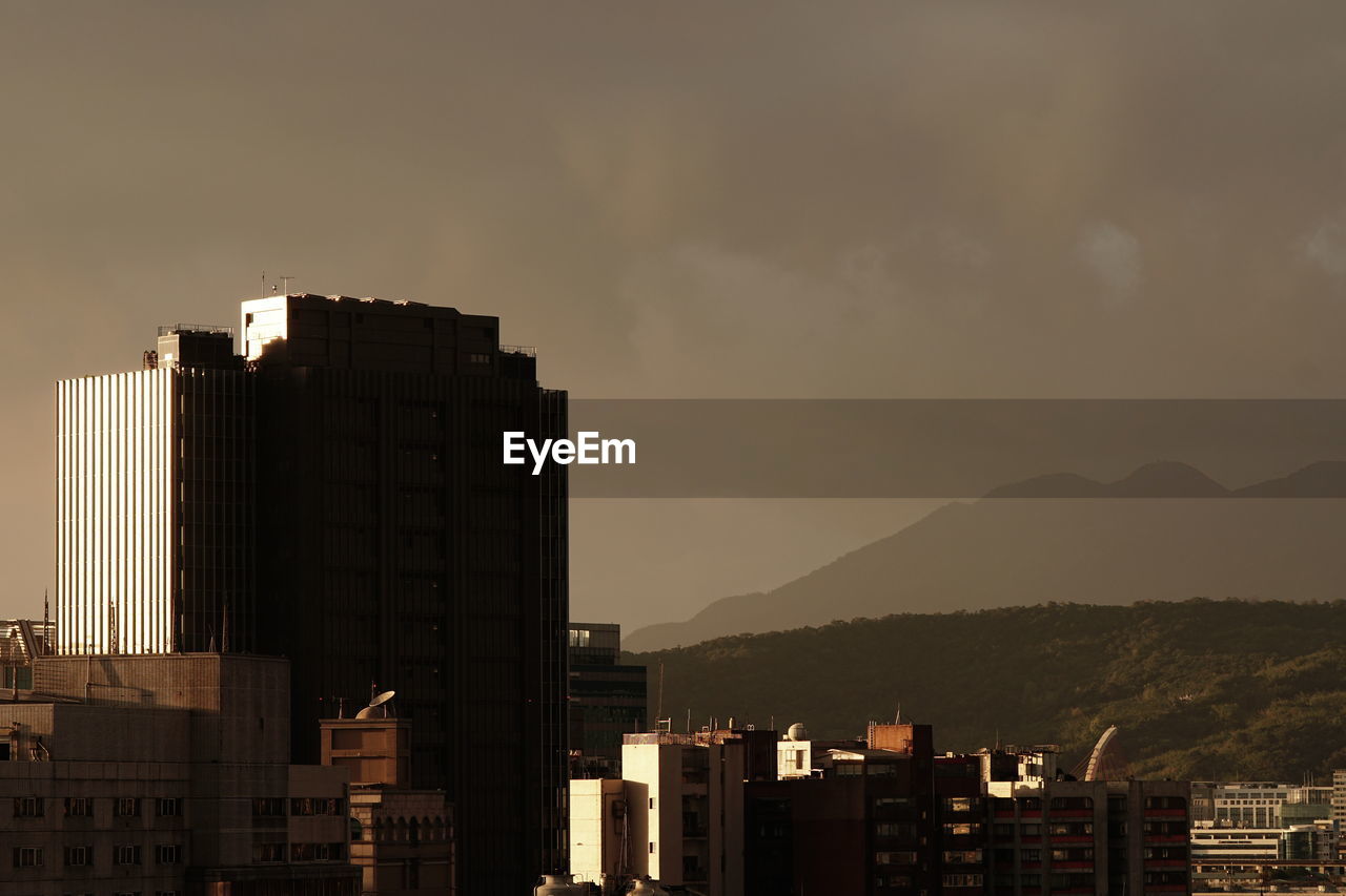 buildings in city against sky at sunset