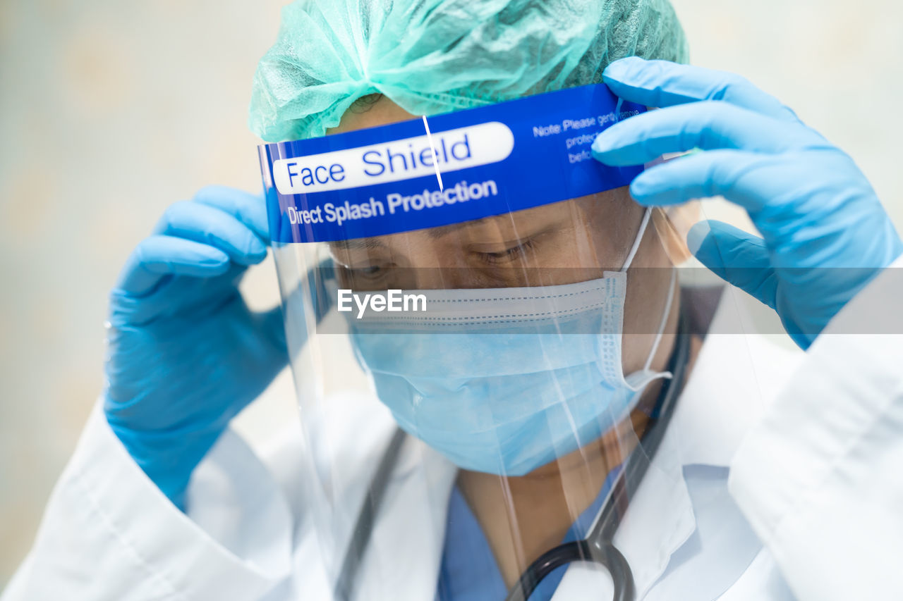Close-up of doctor wearing surgical mask and face shield at hospital