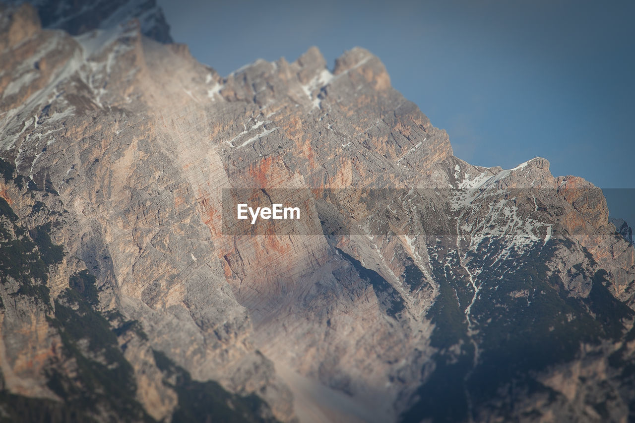 CLOSE-UP OF ROCK FORMATION AGAINST SKY IN WINTER