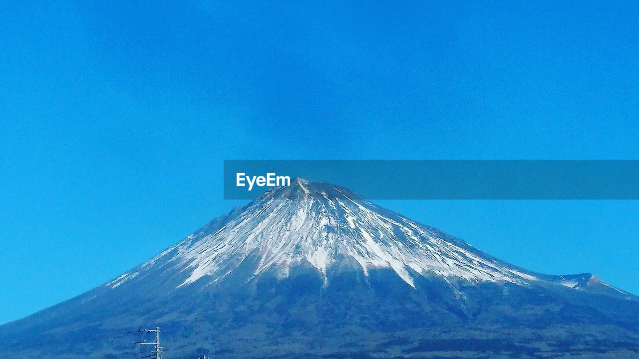 LOW ANGLE VIEW OF SNOWCAPPED MOUNTAIN AGAINST CLEAR SKY