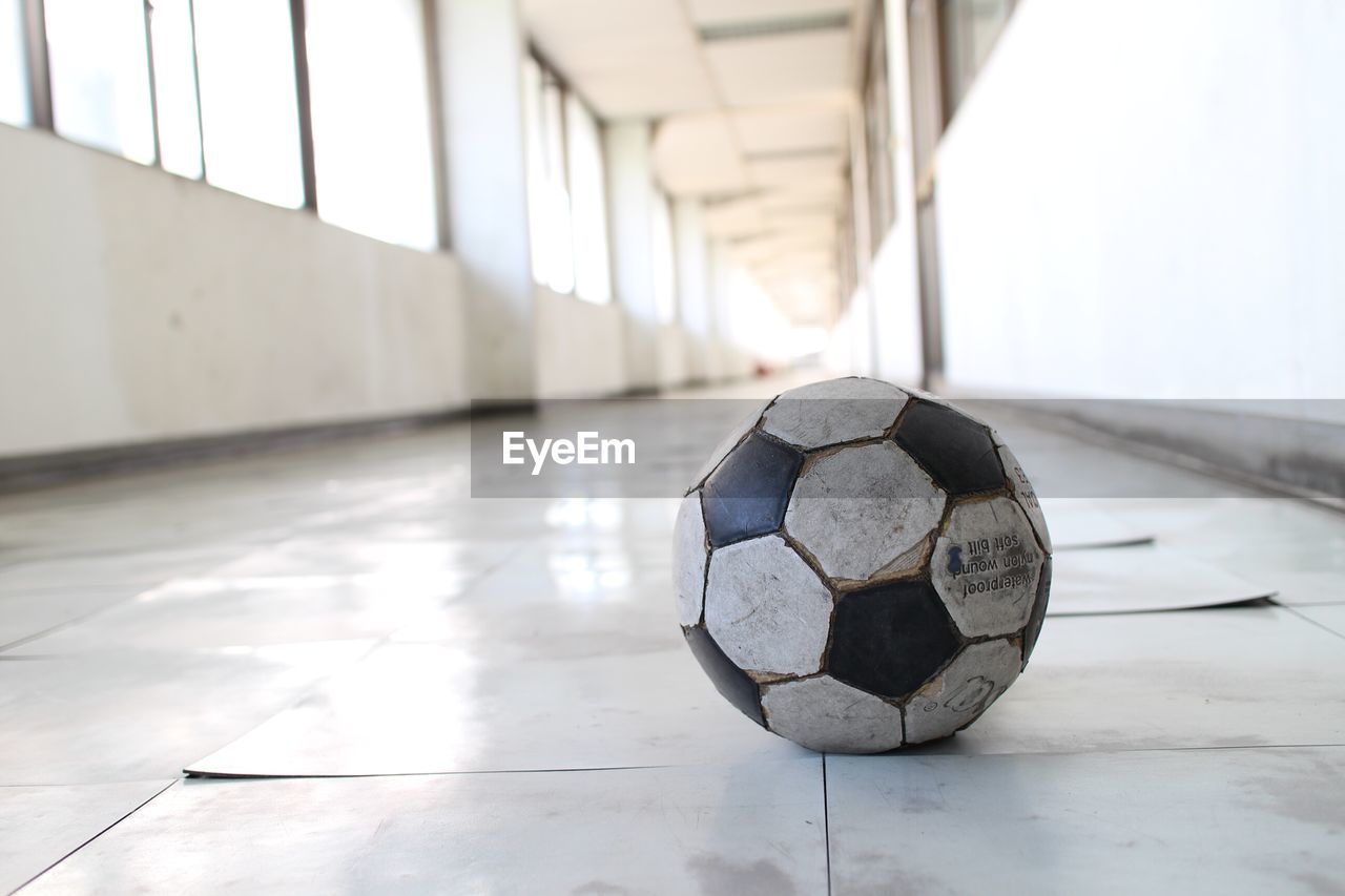 Abandoned soccer ball in corridor of old school building