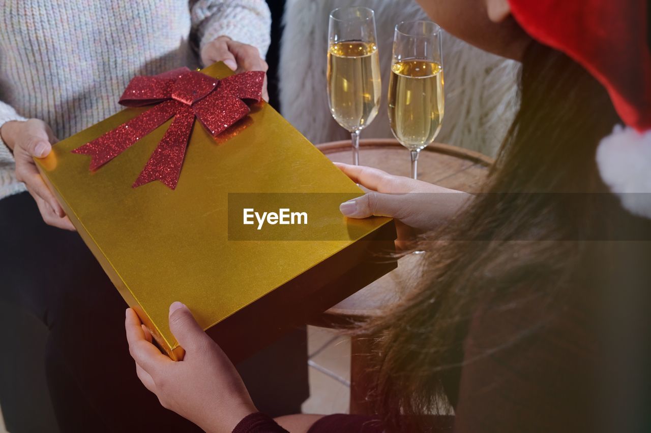 Midsection of man and woman holding gift during christmas