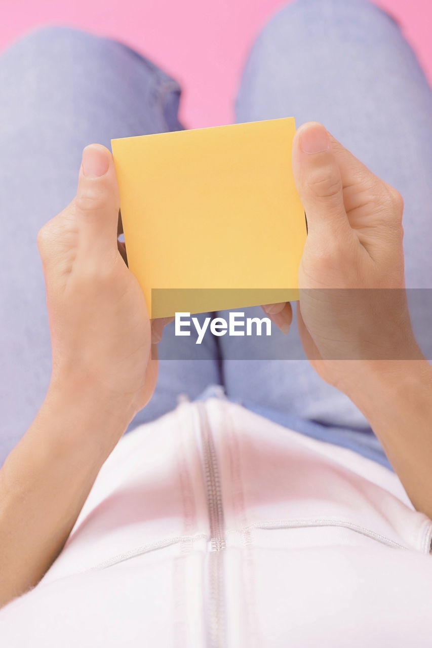 CLOSE-UP OF WOMAN HAND HOLDING BOOK