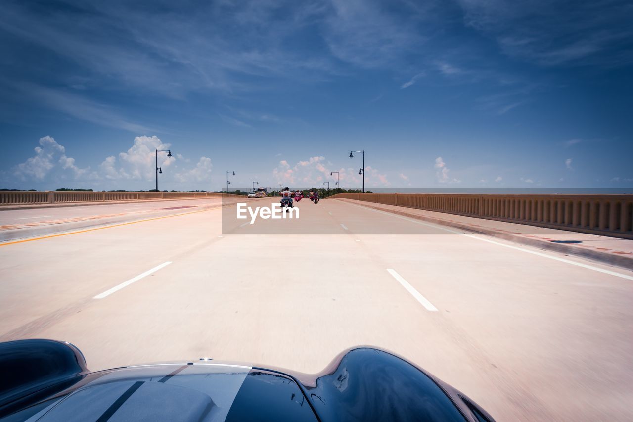 Vehicles on road against sky