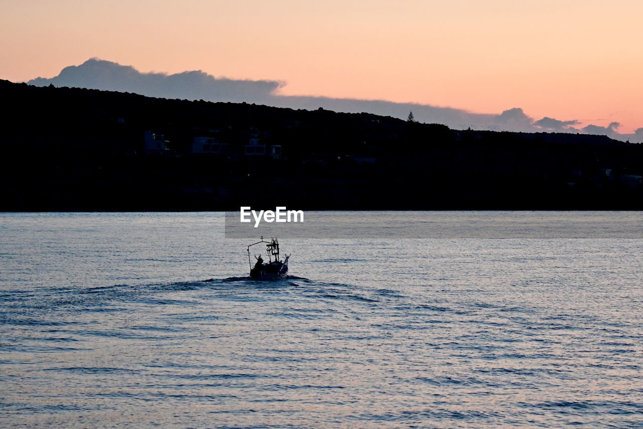 SILHOUETTE BOAT SAILING ON SEA AGAINST ORANGE SKY