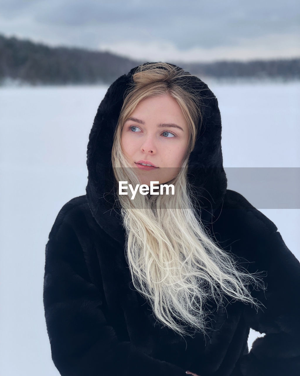 Portrait of young woman standing on snow