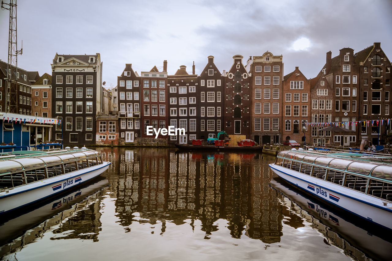 REFLECTION OF BUILDINGS IN CANAL AGAINST SKY
