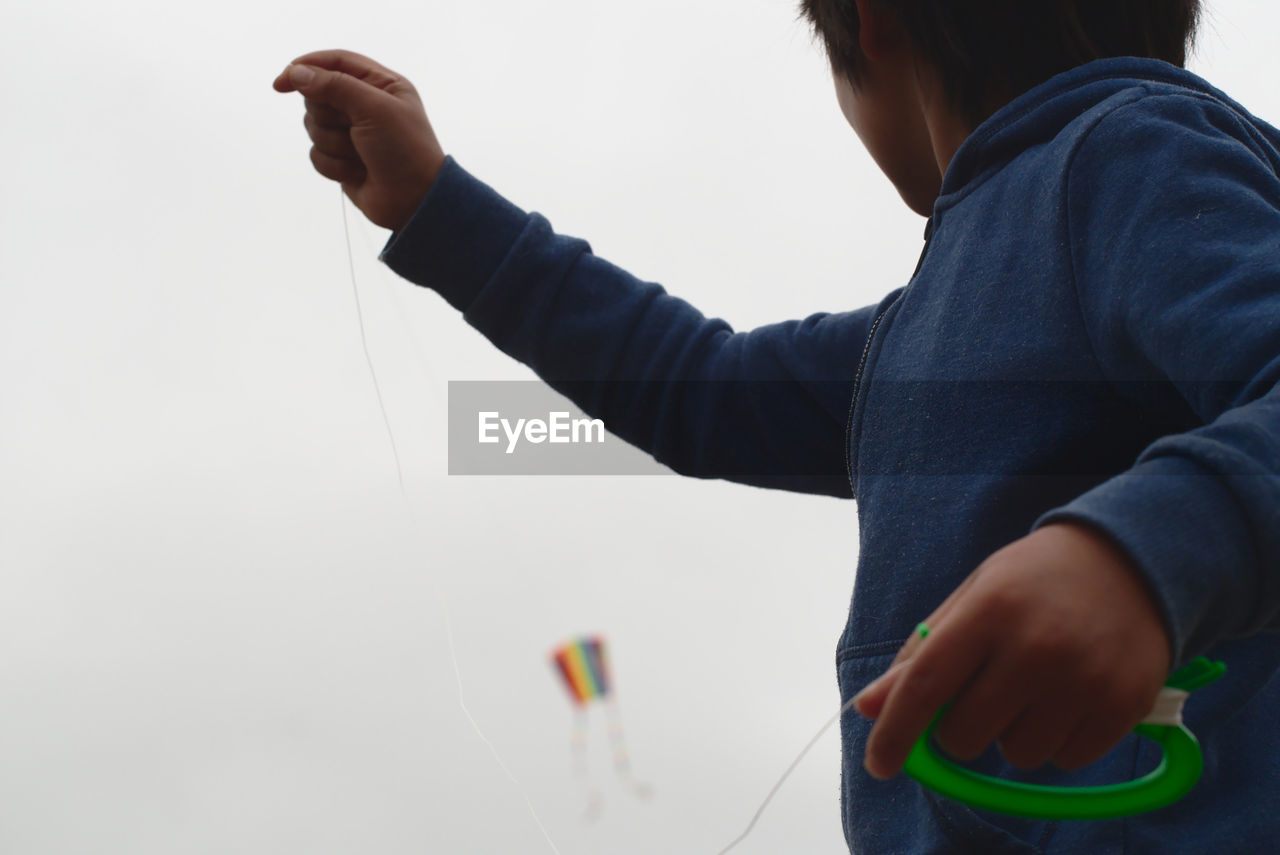 Low angle view of boy flying kite in sky