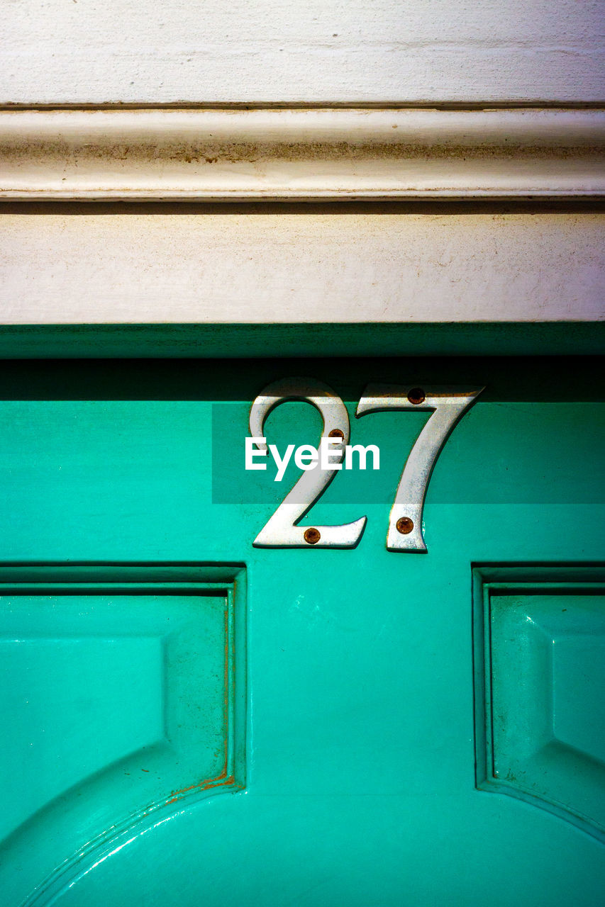 House number 27 on a wooden front door 