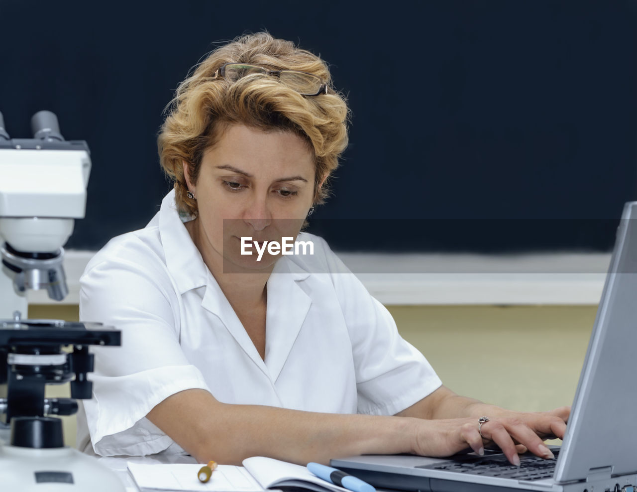 Scientist using laptop at laboratory