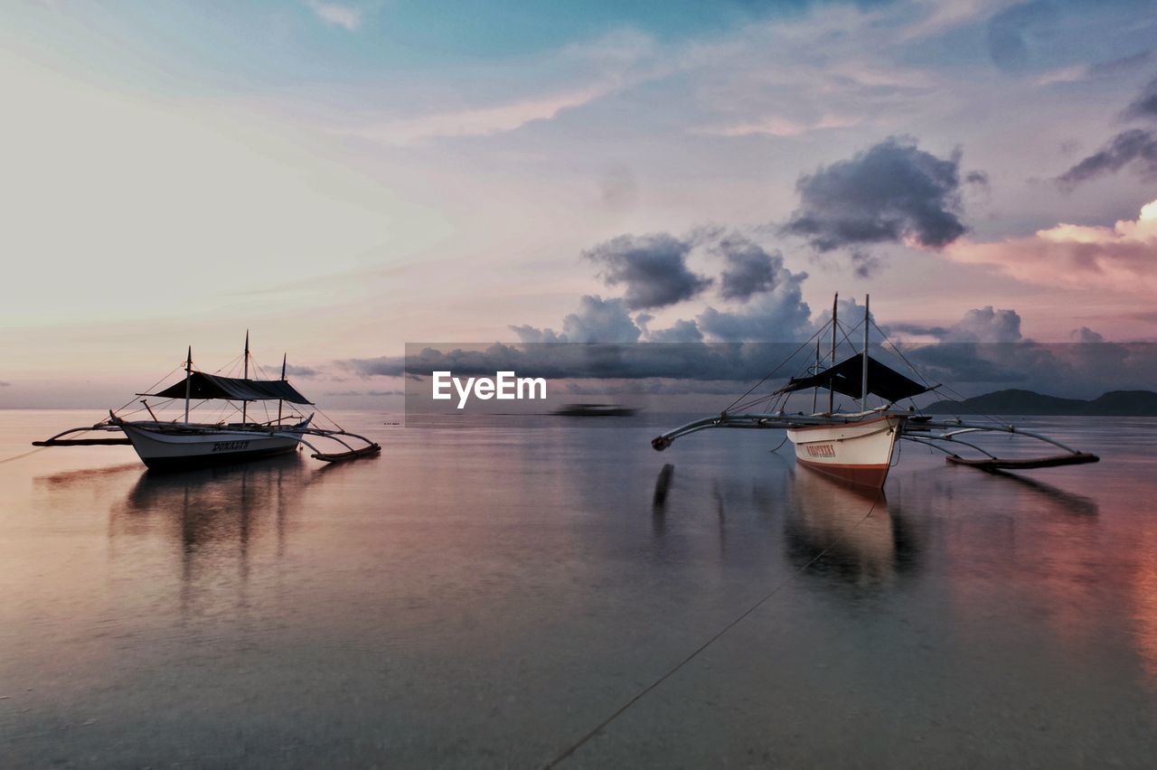 Ship moored on sea against sky during sunset