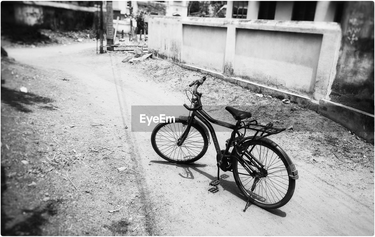 Bicycle parked on road in village during sunny day