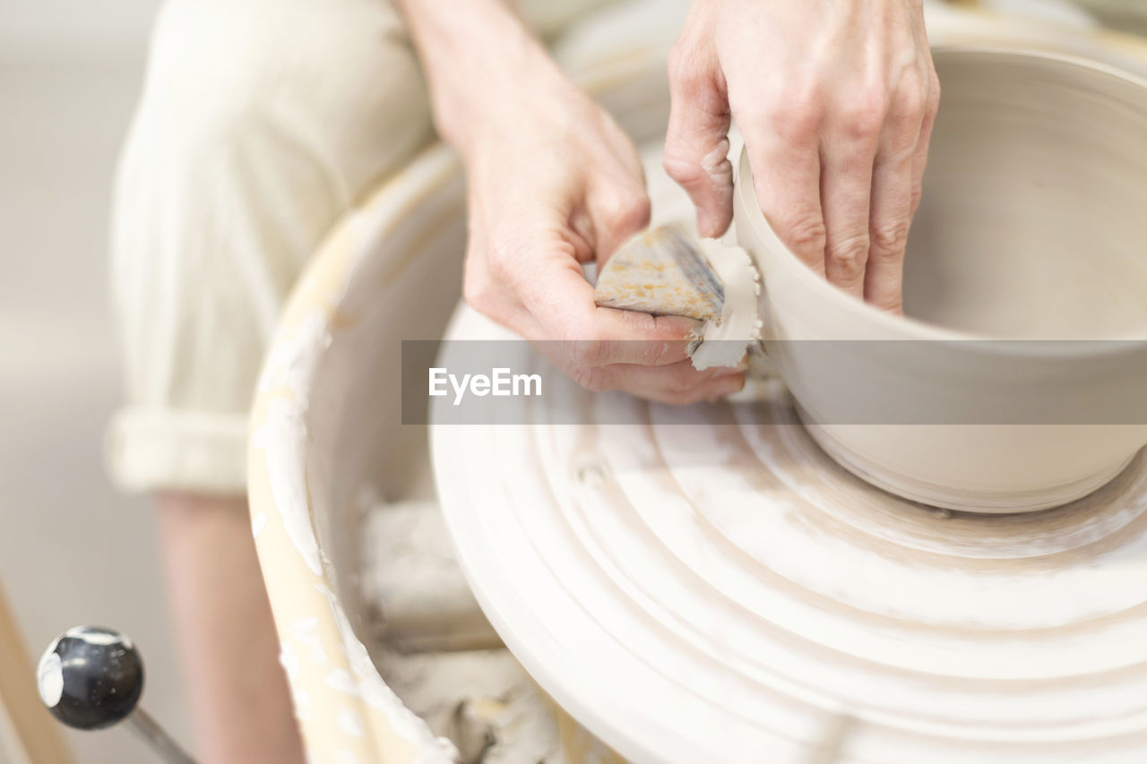 CLOSE-UP OF PERSON PREPARING FOOD IN KITCHEN